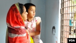 Nasima Akhter holds daughter Arwa, 6, at the main gate of their home in Dhaka, Bangladesh. Akhter’s husband, Sajedul Islam Shumon, disappeared into undisclosed detention in 2013. (A. Rajjak for VOA)