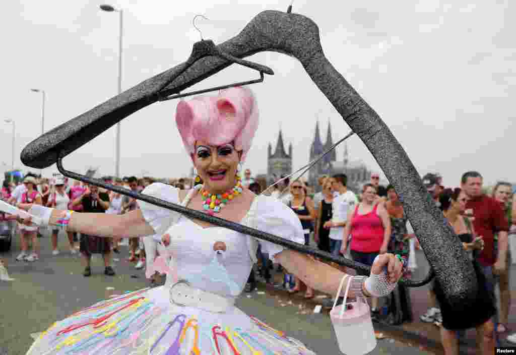A reveler takes part in the annual Christopher Street Day gay parade (CSD) with a huge home-made coat-hanger costume in front of the Cologne Cathedral, western Germany.