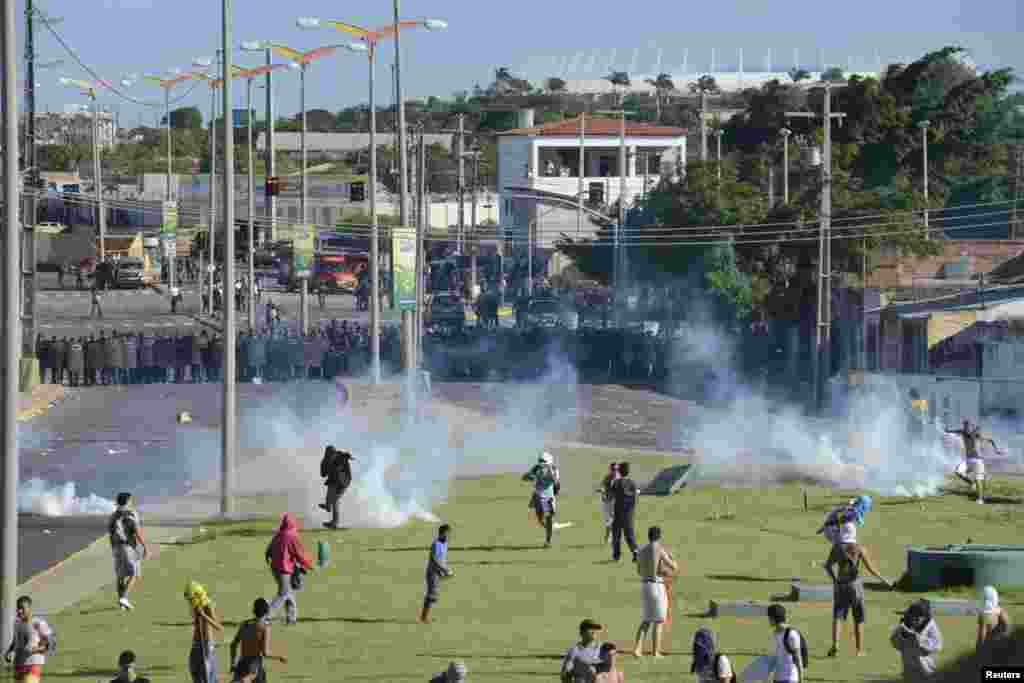 Demonstrators run during clashes with riot police near the Estadio Castelao in Fortaleza, Brazil, June 19, 2013. 