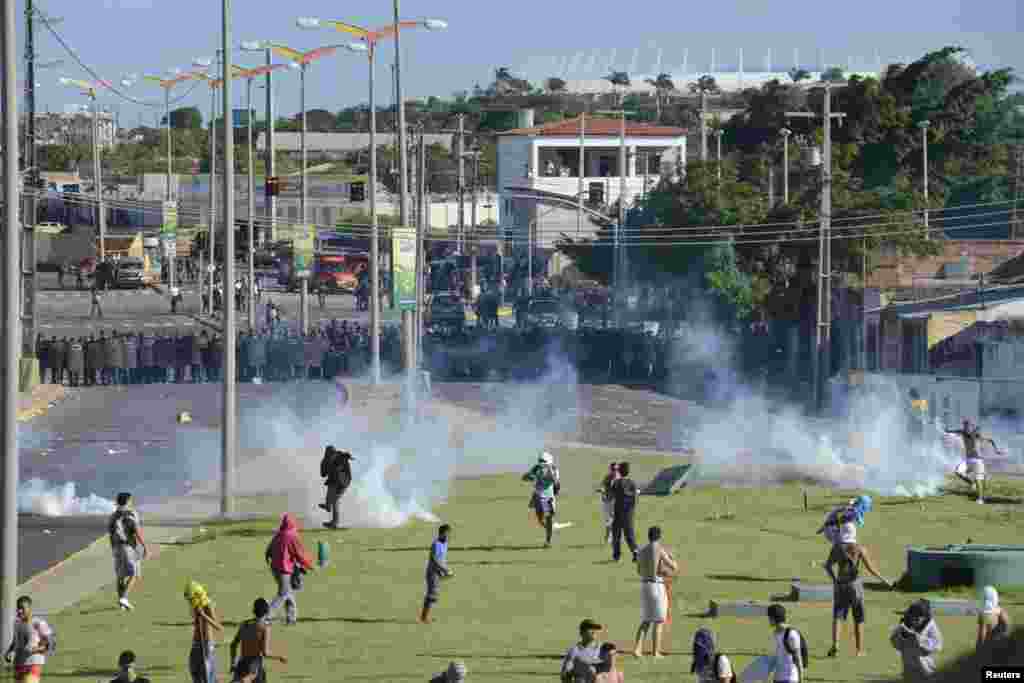 Demonstrators run during clashes with riot police near the Estadio Castelao in Fortaleza, Brazil, June 19, 2013.