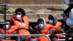 FILE - People thought to be migrants who made the crossing from France are brought into port after being picked up in the Channel by a British border force vessel in Dover, south east England, Thursday, July 22, 2021.