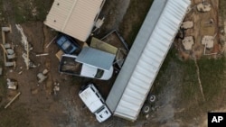 Casas y vehículos que quedaron atrapados en una inundación repentina provocada por el huracán Helene yacen al costado de una carretera cerca del río Swannanoa, el martes 1 de octubre de 2024, en Swannanoa, Carolina del Norte.