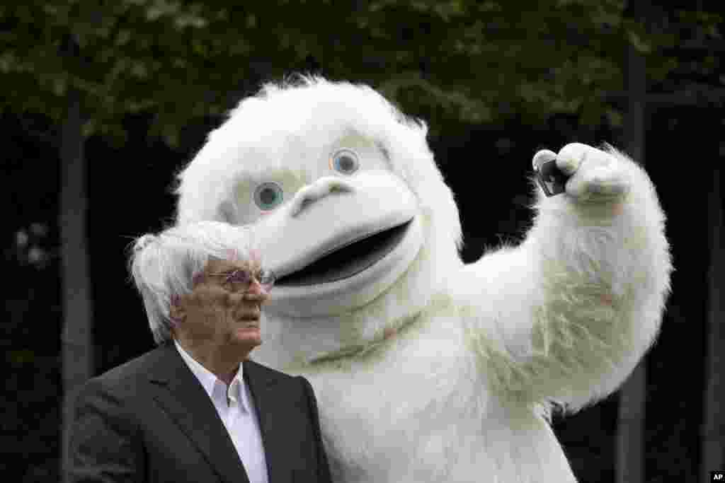 Formula One boss Bernie Ecclestone has a selfie taken with a person dressed in a Yeti costume during a photocall to promote the Mongol Rally, outside the headquarters of Formula One Group in London.
