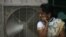 FILE - An Indian women stands in front of an air cooler to cool herself on a hot summer day in Hyderabad, in the southern Indian state of Telangana. The equatorial Pacific Ocean’s climate cycle “El Niño” effect, a warming of sea surface temperatures that occurs every few years, is getting much of the blame for the heat wave and drought. 