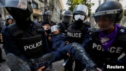 Polisi Thailand mengangkut seorang rekannya yang terluka dalam bentrokan dengan demonstran anti pemerintah di Stadion Olahraga di Bangkok, Kamis (26/12). 