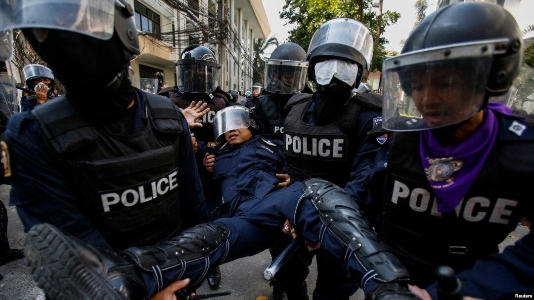 Polisi Thailand mengangkut seorang rekannya yang terluka dalam bentrokan dengan demonstran anti pemerintah di Stadion Olahraga di Bangkok, Kamis (26/12). 