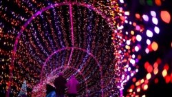 A couple walks through a tunnel of light during the annual Garden Glow at the Missouri Botanical Garden, in St. Louis, Dec. 3, 2019.