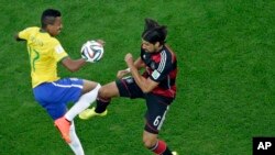 Brazil's Luiz Gustavo (l) and Germany's Sami Khedira, go for the ball during the World Cup semifinal soccer match between Brazil and Germany at the Mineirao Stadium in Belo Horizonte, Brazil, July 8, 2014. 