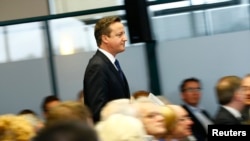 Britain's Prime Minister David Cameron takes to the stage to deliver a speech on the economy, in Nottingham, central England, Jan. 2, 2015. 