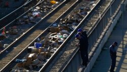 Men look over a railing at a Union Pacific railroad site on Jan. 20, 2022, in Los Angeles.