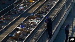 Men look over a railing at a Union Pacific railroad site on Jan. 20, 2022, in Los Angeles.