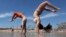 Dan Copeland, left, and Alex Morneau of Biddeford, Maine, former high school cheerleaders, perform back flips while enjoying the record breaking heat at Old Orchard Beach, Maine, May 18, 2017. The temperature climbed well into the 90s in many locations throughout the state. 