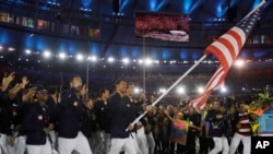 在里约奥运会开幕式上，荣获多面游泳金牌的菲尔普斯举着美国国旗率领美国队走进体育馆（2016年8月5日）