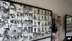 A tourist walks past photos of former prisoners displayed at Tuol Sleng genocide museum, a former Khmer Rouge prison known as S-21, in Phnom Penh.