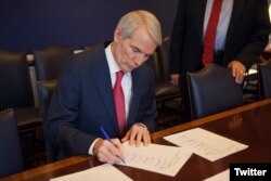 El senador Rob Portman, republicano por Ohio, firma el Reporte de la Conferencia de las dos Cámaras del Congreso de EE.UU. sobre la Ley de Recorte Impositivo y Empleos. Dic. 15, 2017. Foto: @senrobportman.