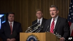 Ron Hosko, directeur adjoint de la Division des enquêtes criminelles du FBI, à droite, prend la parole lors d'une conférence de presse au siège du FBI à Washingotn, le lundi 29 Juillet 2013, à propos de l'opération «Cross Country."