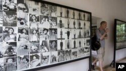 A tourist walks past photos of former prisoners displayed at Tuol Sleng genocide museum, a former Khmer Rouge prison known as S-21, in Phnom Penh.