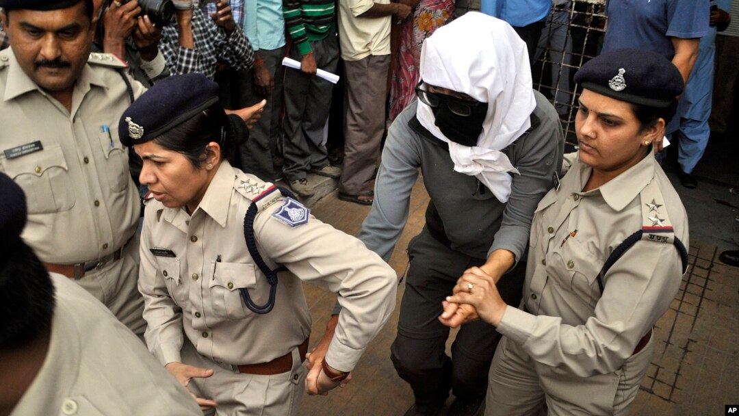 Perempuan warga Swiss (tengah, ditutupi wajahnya) dikawal polisi India setelah menjalani pemeriksaan di rumah sakit di Gwalior, India usai kasus pemerkosaan oleh lima pria (16/5). 