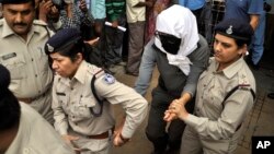 Perempuan warga Swiss (tengah, ditutupi wajahnya) dikawal polisi India setelah menjalani pemeriksaan di rumah sakit di Gwalior, India usai kasus pemerkosaan oleh lima pria (16/5). 