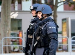 After a shooting armed police officers patrol on a street at the scene in Vienna, Austria, Tuesday, Nov. 3, 2020.