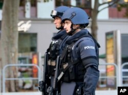 After a shooting armed police officers patrol on a street at the scene in Vienna, Austria, Tuesday, Nov. 3, 2020.
