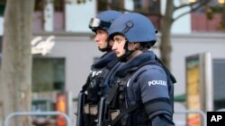 After a shooting armed police officers patrol on a street at the scene in Vienna, Austria, Nov. 3, 2020. 