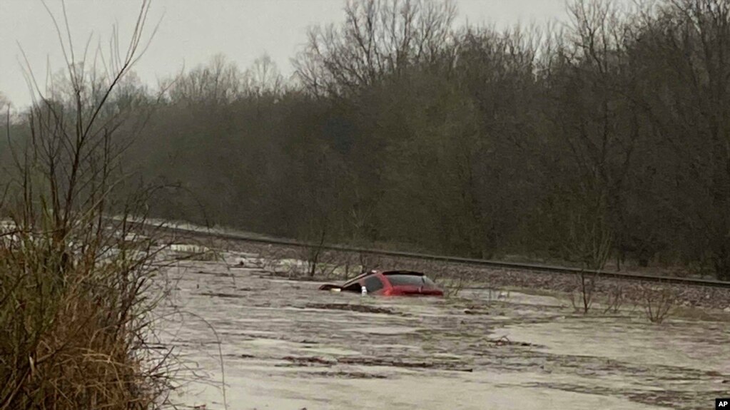 En esta imagen cortesía de Layton Hoyer, se ve una camioneta roja sumergida en las inundaciones, el viernes 24 de marzo de 2023 en Granby, Missouri.