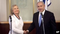 Menteri Luar Negeri AS, Hillary Clinton (kiri) berjabat tangan dengan PM Israel Benjamin Netanyahu di kantornya di Yerusalem (16/7).