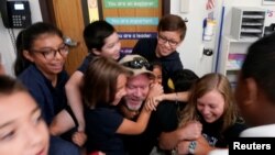 Joe Emery, TAC*ONE trainer and former Las Vegas police department sergeant, is swarmed by fifth grade students in a shooter take down exercise at Pinnacle Charter School during TAC*ONE training for an active shooter situation in a school in Thornton, Colo