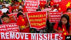 Demonstrators display placards during a rally at the Chinese Consulate to protest Beijing's militarization of disputed islands in the South China Sea, in Manila, Philippines, Feb. 25, 2016.