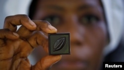 A worker holds a piece of Mon Choco" chocolate, handmade organic raw chocolates made with cocoa beans ground with a bicycle in Abidjan, Ivory Coast January 10, 2019.