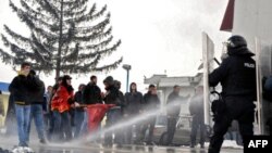 Kosovski policajci rasteruju suzavcem i vodenim topom pristalice pokreta Samoopredeljenje, 14 januara 2012. godine, kod Podujeva u blizini prelaza Merdare.