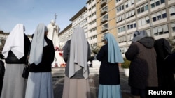 Nuns pray outside the Gemelli Hospital where Pope Francis is admitted for treatment, in Rome, Italy, Feb. 23, 2025. 