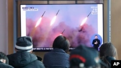 People watch a TV showing file images of North Korea's missile launch during a news program at the Seoul Railway Station in Seoul, South Korea, March 9, 2020.