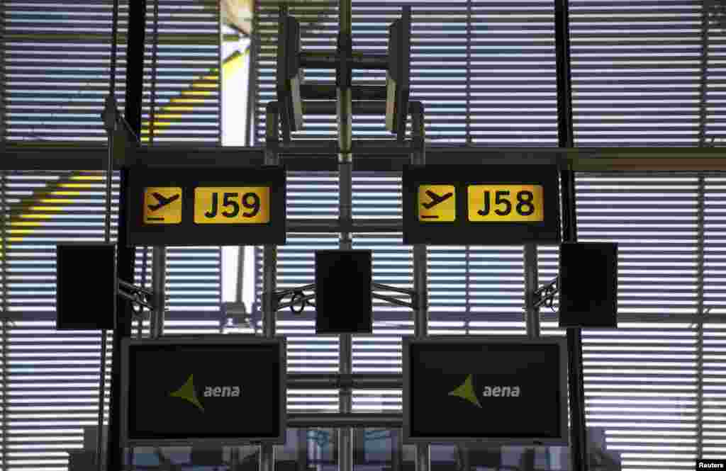 The logo of Spanish airport operator AENA is displayed on screens above boarding gates at Terminal 4 of Madrid&#39;s Adolfo Suarez Barajas airport. 