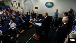 Flanked by members of the coronavirus task force, President Donald Trump speaks during a news briefing on the coronavirus outbreak in the U.S., at White House, March 20, 2020, in Washington.