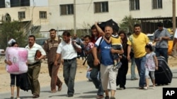 Palestinians carry their belongings as they head towards the newly-opened border crossing to Egypt in Rafah, in the southern Gaza Strip, 01 Jun, 2010