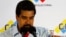 Acting Venezuelan President Nicolas Maduro holds a picture of the late President Hugo Chavez during a news conference at the election commission in Caracas, April 14, 2013. 