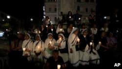 FILE - The faithful gather in front of the Vatican's Basilica of St. Mary Mayor in Rome, Sunday, Oct. 15, 2023, to lead a prayer for peace in the Middle East.