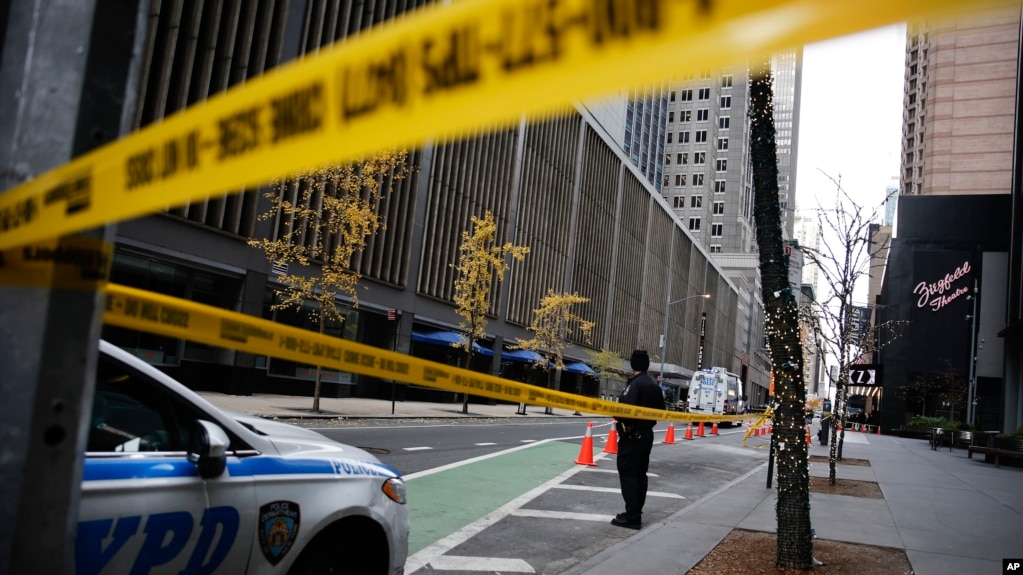 Un oficial de policía de Nueva York se encuentra en la calle 54 frente al Hotel Hilton en el centro de Manhattan, donde Brian Thompson, director ejecutivo de UnitedHealthcare, recibió un disparo mortal el miércoles 4 de diciembre de 2024 en Nueva York. AP