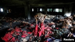 Seorang pekerja pabrik garmen melakukan inspeksi setelah musibah kebakaran di Dhaka, Bangladesh (9 Mei 2013). 