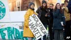 Swedish environmental activist Greta Thunberg holds a sign with writing reading in Swedish "School strike for the climate" as she attends a climate march, in Turin, Italy, Dec. 13, 2019. 