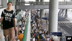 Stranded passengers queue up in lines to wait for special buses at Kansai International Airport following a powerful typhoon in Osaka, western Japan, Wednesday, Sept. 5, 2018. (Kyodo News via AP)