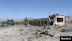 FILE - Afghan security forces inspect the aftermath of a suicide bomb blast in Gardez, Paktia Province, Afghanistan, June 18, 2017. 