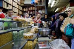 Ibu-ibu belanja makan ringan di sebuah pasar di Jakarta untuk menyambut Idul Fitri, 3 Juni 2019. (Foto: Reuters)