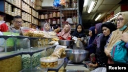 Ilutrasi. Ibu-ibu belanja makan ringan di sebuah pasar di Jakarta untuk menyambut Idul Fitri, 3 Juni 2019. (Foto: Reuters)