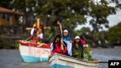 Fieles católicos conmemoran el Via Crucis en el Lago Nicaragua durante las celebraciones de Semana Santa el 30 de marzo de 2021.