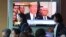People pass by a TV screen showing a footage of U.S. President Donald Trump during a news program at the Seoul Railway Station in Seoul, South Korea, May 25, 2018. 