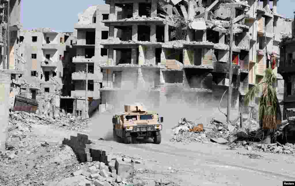 An armored vehicle of the Syrian Democratic Forces is seen driving along a road at the frontline in Raqqa, Syria.