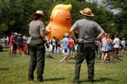 National Park Service rangers view a Baby Trump balloon before Independence Day celebrations on the National Mall in Washington, July 4, 2019.